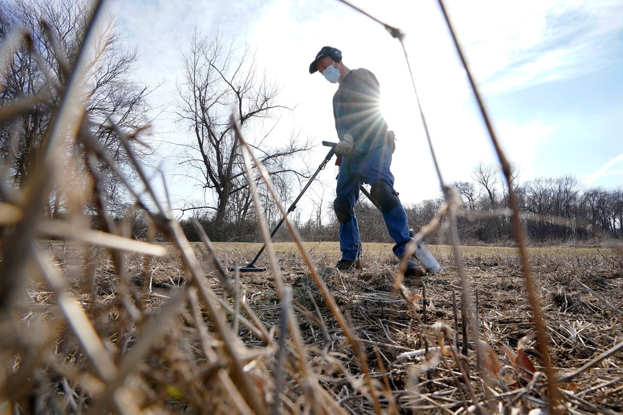 El historiador aficionado Jim Bailey usa un detector de metales en busca de artefactos de la época colonial en un campo en Warwick, Rhode Island, 11 de marzo de 2021.