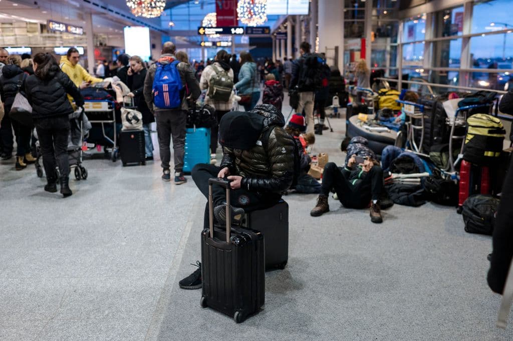 Viajeros varados en el aeropuerto tras el caos por cancelaciones y retrasos debido al temporal de invierno.