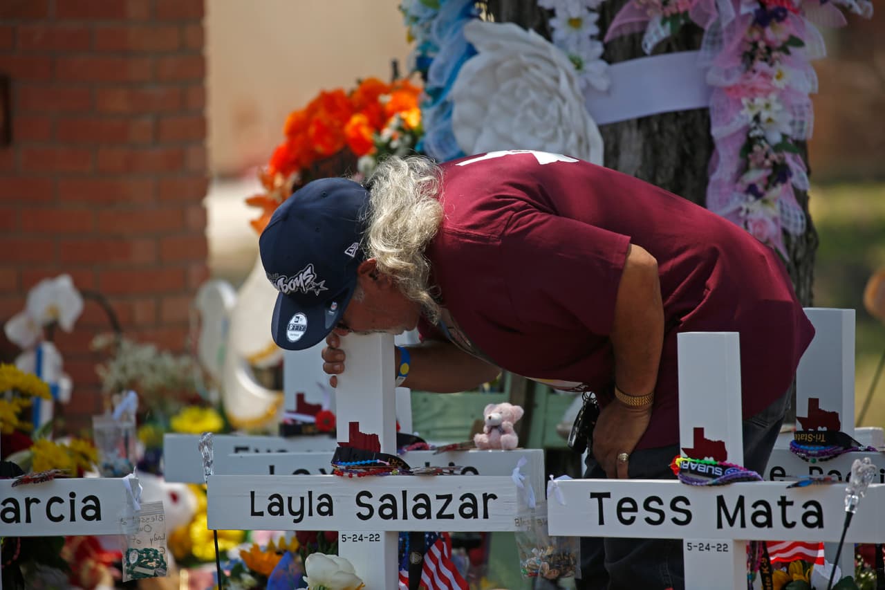 Una persona abraza la cruz en memoria de Layla Salazar, una de las niñas asesinadas en la Escuela Primaria Robb, este sábado.