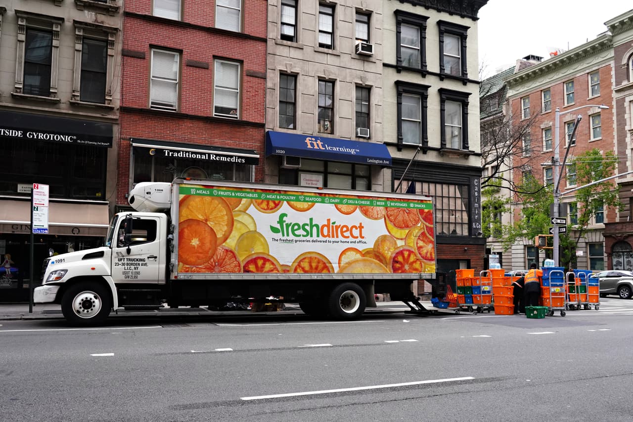 Un camión de FreshDirect se estaciona mientras los trabajadores empacan los alimentos para ser entregados. Muchas personas piden su despensa por Internet y la reciben en la puerta de su casa. Así, evitan ir al mercado y arriesgarse a ser contagiados.