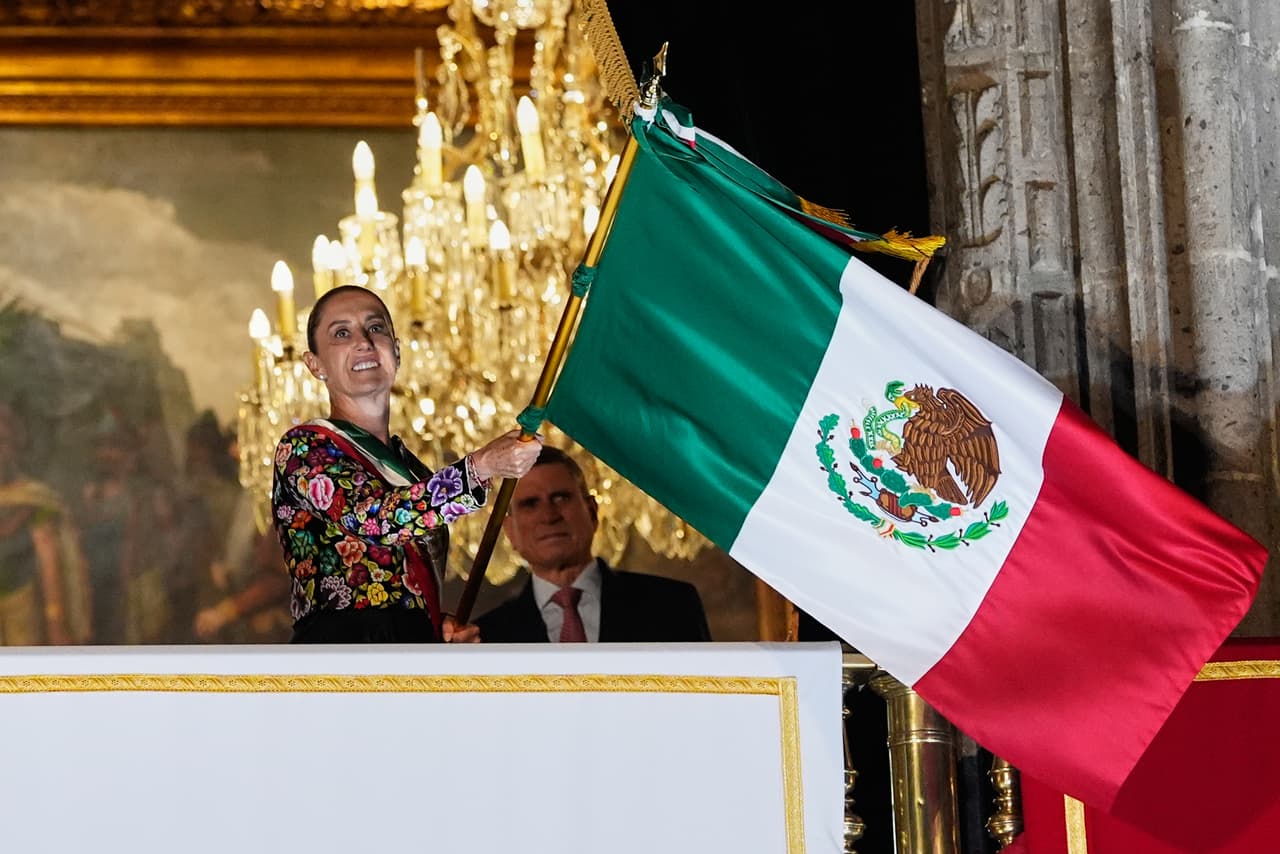 La presidenta Claudia Sheinbaum sostiene una bandera mexicana durante el tradicional Grito de Independencia desde el balcón del Palacio Nacional, dando inicio a las celebraciones del Día de la Independencia en el Zócalo —la plaza principal de la Ciudad de México— el martes 15 de septiembre de 2026.