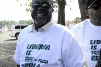 El ministro de Información de Liberia, Lewis Brown, porta una playera con la leyenda "Liberia está libre de ébola".