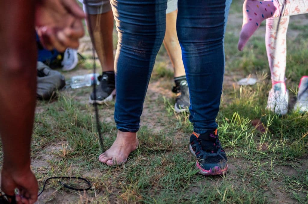 <b>Venezuela. </b>Después de cruzar el Río Grande hacia Estados Unidos, un grupo de migrantes se quita los cordones de los zapatos a pedido de los funcionarios de migración en Del Río, Texas. Según el último reporte de la Agencia de las Naciones Unidas para los Refugiados (ACNUR), 
<b>hay 5.4 millones de venezolanos refugiados, migrantes o solicitando asilo en el mundo.</b> Entre 2013 y lo que va de 2021, ha habido 15,161 casos resueltos de venezolanos que piden refugio en México, la mayoría de ellos con una respuesta favorable. Eso coloca al 
<b>país sudamericano en el tercero en la lista, solo después de los hondureños</b> (con 24,477 casos aceptados de los más de 31,000) 
<b>y los salvadoreños</b> (con más de 11,000 entre las 15,360 peticiones).