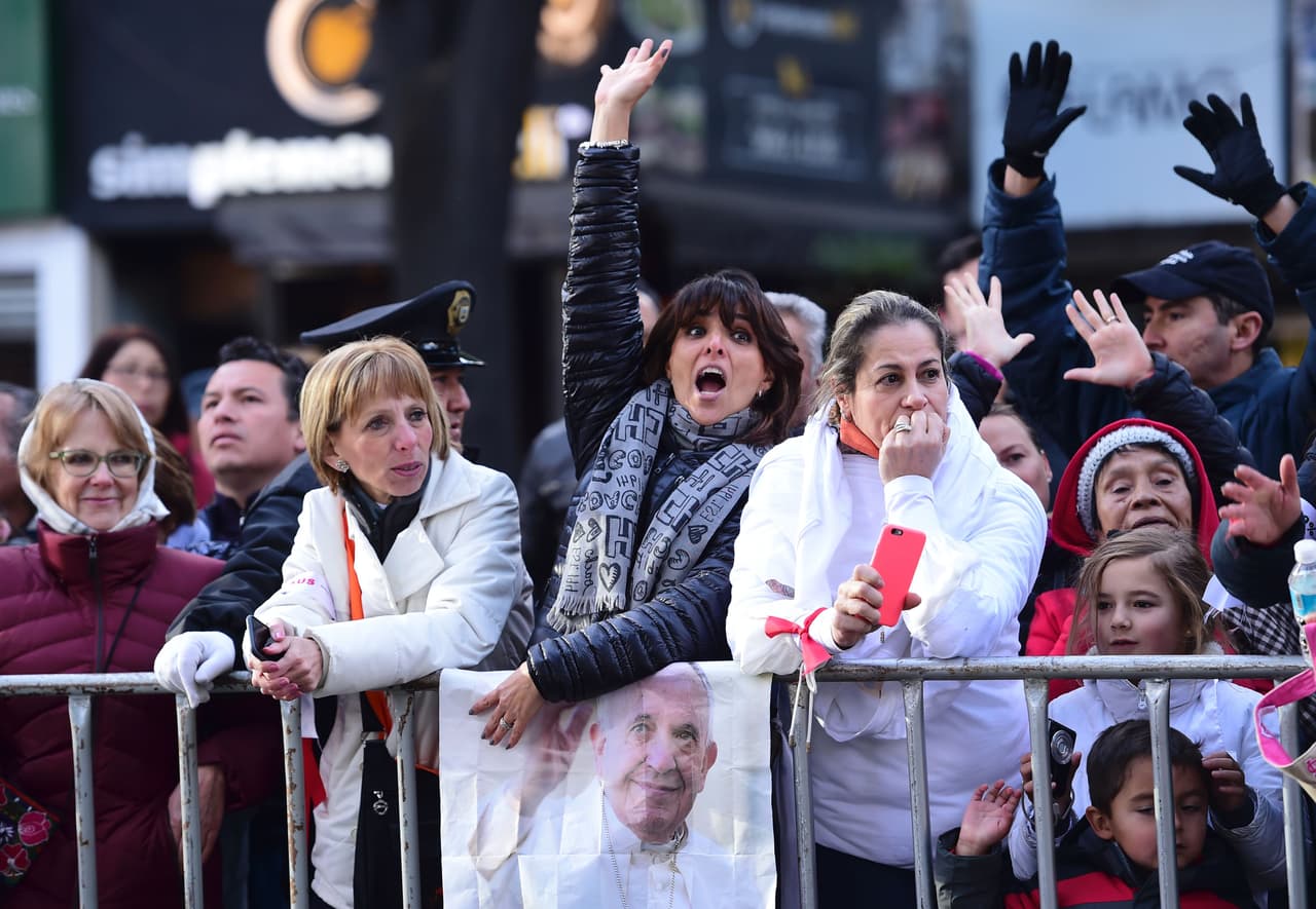 Esta mujer alza la mano para que el Papa Francisco la mire.