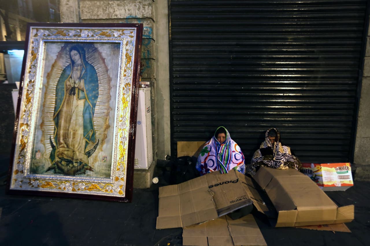 Dos mujeres junto a una imagen de la Virgen de Guadalupe esperando ver al Papa Francisco cerca de la Basílica.