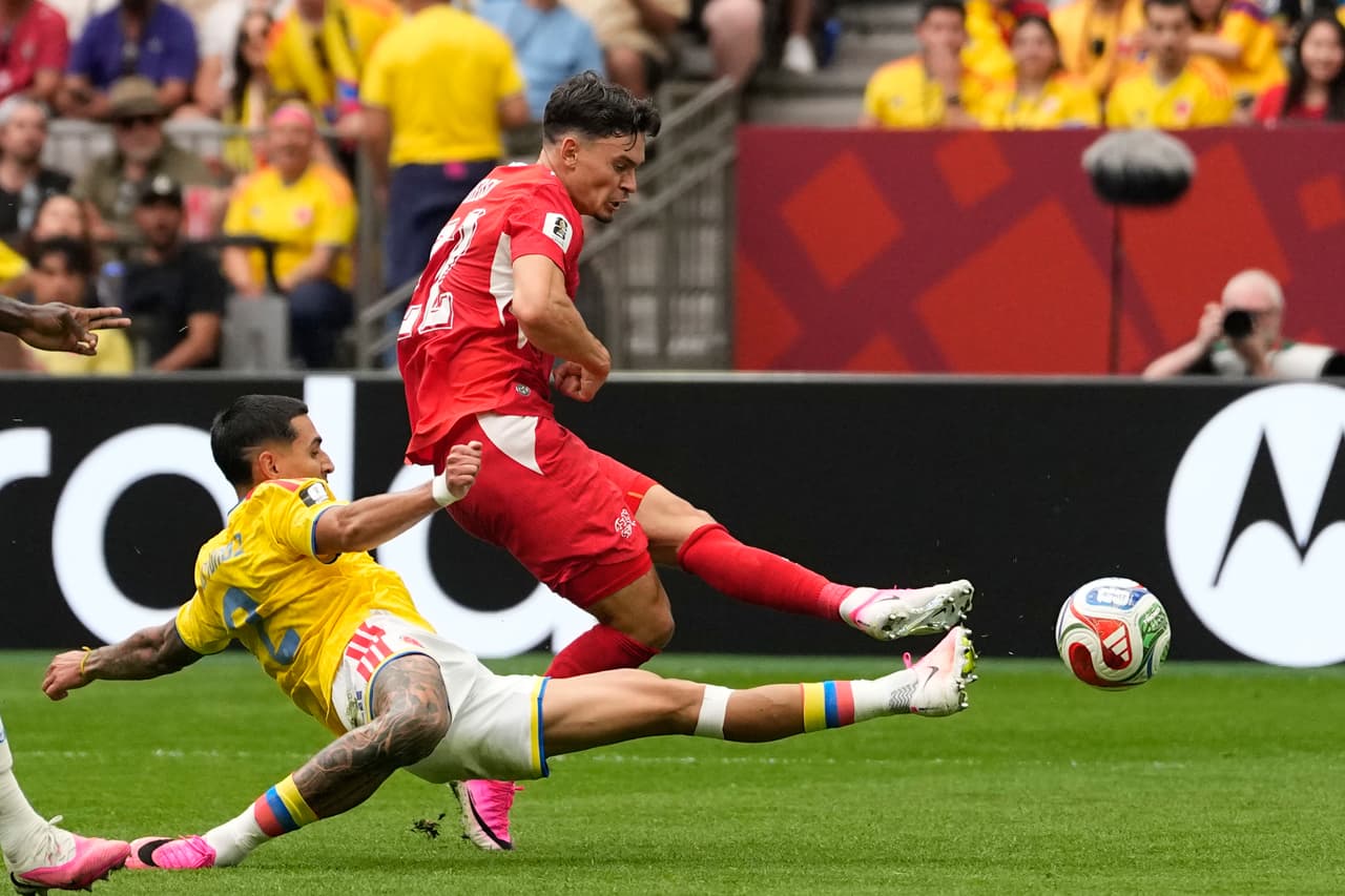 El colombiano Daniel Muñoz (izquierda) bloquea un disparo del suizo Fabian Rieder durante el partido de octavos de final de la Copa del Mundo entre Suiza y Colombia en Vancouver, Columbia Británica, el martes 7 de julio de 2026.