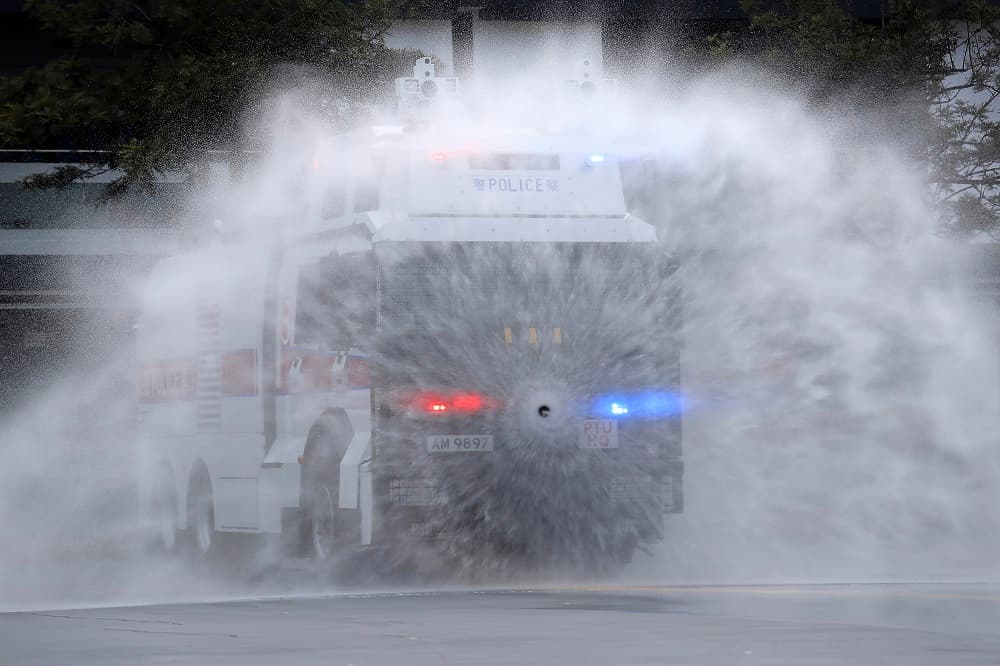 Según la web 
<i>Hong Kong Free Press</i>, los miles de manifestantes que se congregaron en el aeropuerto lo hicieron para protestar contra el uso de la fuerza por la Policía durante el fin de semana, que dejó enfrentamientos en una estación de metro, donde agentes antidisturbios dispersaron a la multitud con gas lacrimógeno. La fotografía muestra un vehículo lanzando agua este lunes en una demostración de la capacidad de las autoridades para controlar protestas.