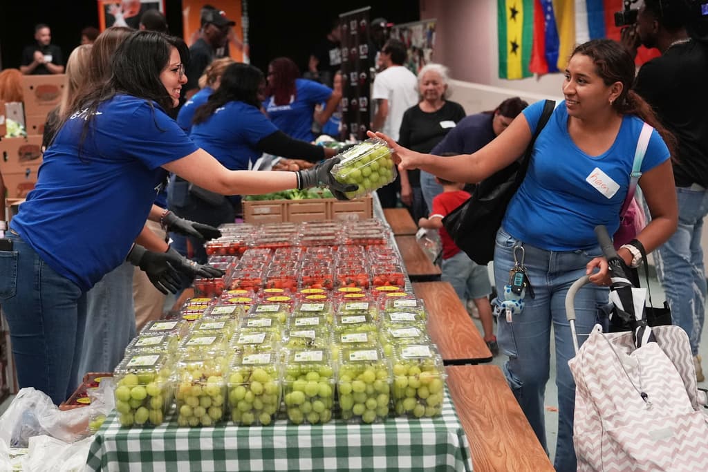 Karen Mendieta, a la derecha, recibe uvas verdes en el banco de alimentos en Hollywood.
