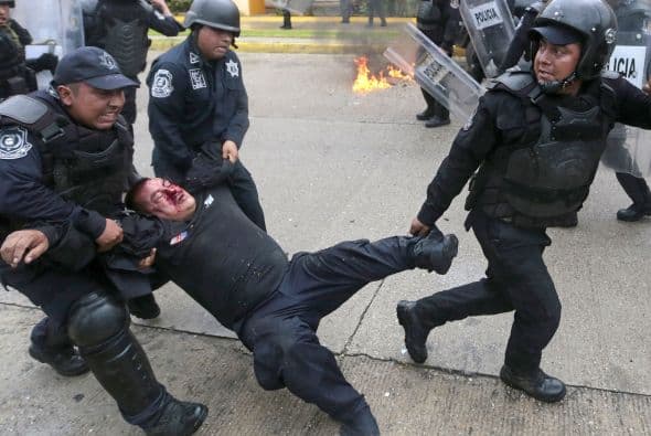 Uno de los policías heridos fue llevado por sus compañeros a una ambulancia.