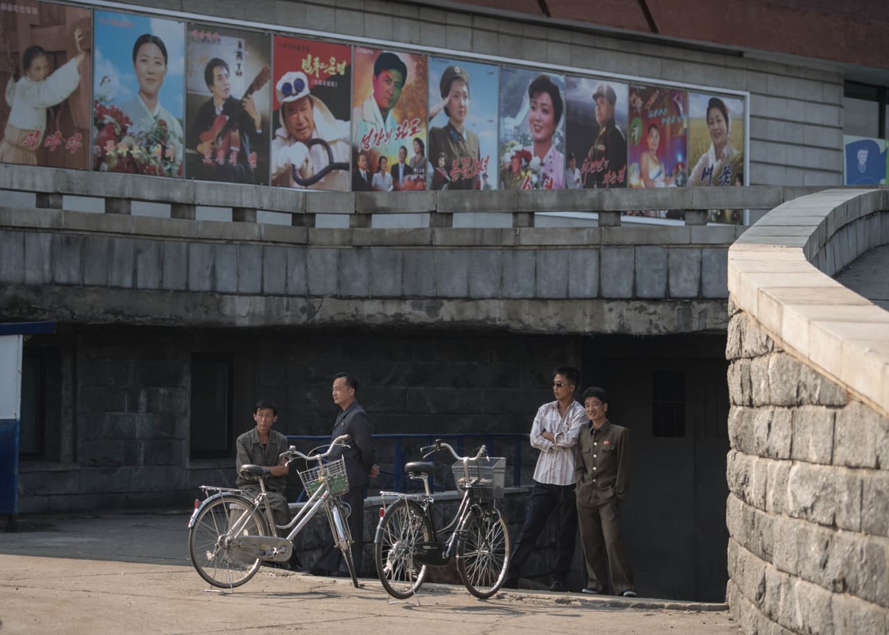 Algunos ciclistas esperan frente al teatro internacional de Pyongyang, durante el décimo quinto cine de la ciudad. 23 de septiembre de 2016.