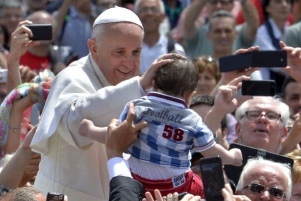 En esta foto el Papa bendice a Francis un pequeñito que se acerca a él cuando sale en su papamobile después de la Santa Misa en la Plaza de San Pedro en el Vaticano.