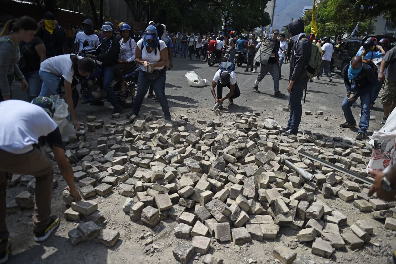 El canciller ruso, Sergei Lavrov, le dijo a su par de Estados Unidos, Mike Pompeo, que más medidas "agresivas" en Venezuela crearían una tensión con graves consecuencias. En la fotografía los manifestantes opositores colectan piedras para lanzarlas a los antimotines.
