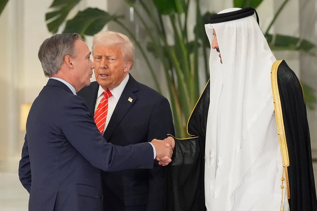 El emir de Qatar, el jeque Tamim bin Hamad Al Thani, estrecha la mano de Kelly Ortberg, presidente y director ejecutivo de The Boeing Company, en presencia del presidente estadounidense Donald Trump, durante una cena en Doha, Catar, el miércoles.