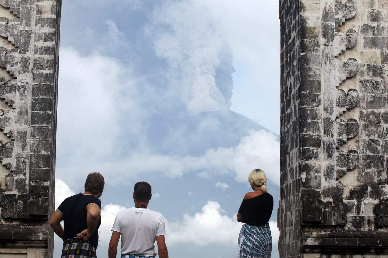 Turistas miran la erupción desde el templo de Karangasem. El aeropuerto continúa cerrado.