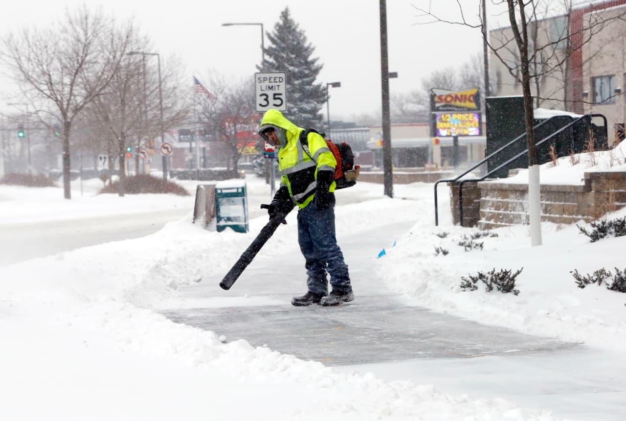 Un hombre limpia la acera de su casa en Bloomington, Minnesota.