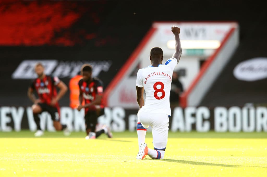 Cheikhou Kouyate, jugador del Crystal Palace con el puño al cielo y la rodilla en el césped previo a jugar contra el Bournemouth.