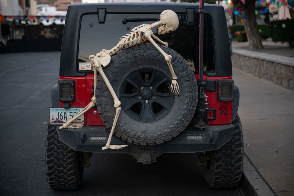 Evita adornos que interfieran con la visibilidad del conductor o las luces del auto, como cubrir parabrisas o ventanas con telas o carteles. Y claro 
<b>no cubras tu rostro con máscaras mientras manejas, </b>pues podrían afectar tu control y visión al volante. 
<br>
<br>En la imegan puedes ver un ejemplo de adorno que puede bloquear la visión del retrovisor. Si consigues que no sea tan alto y no interfiera con tu vista, podría ser una gran idea de decoración.