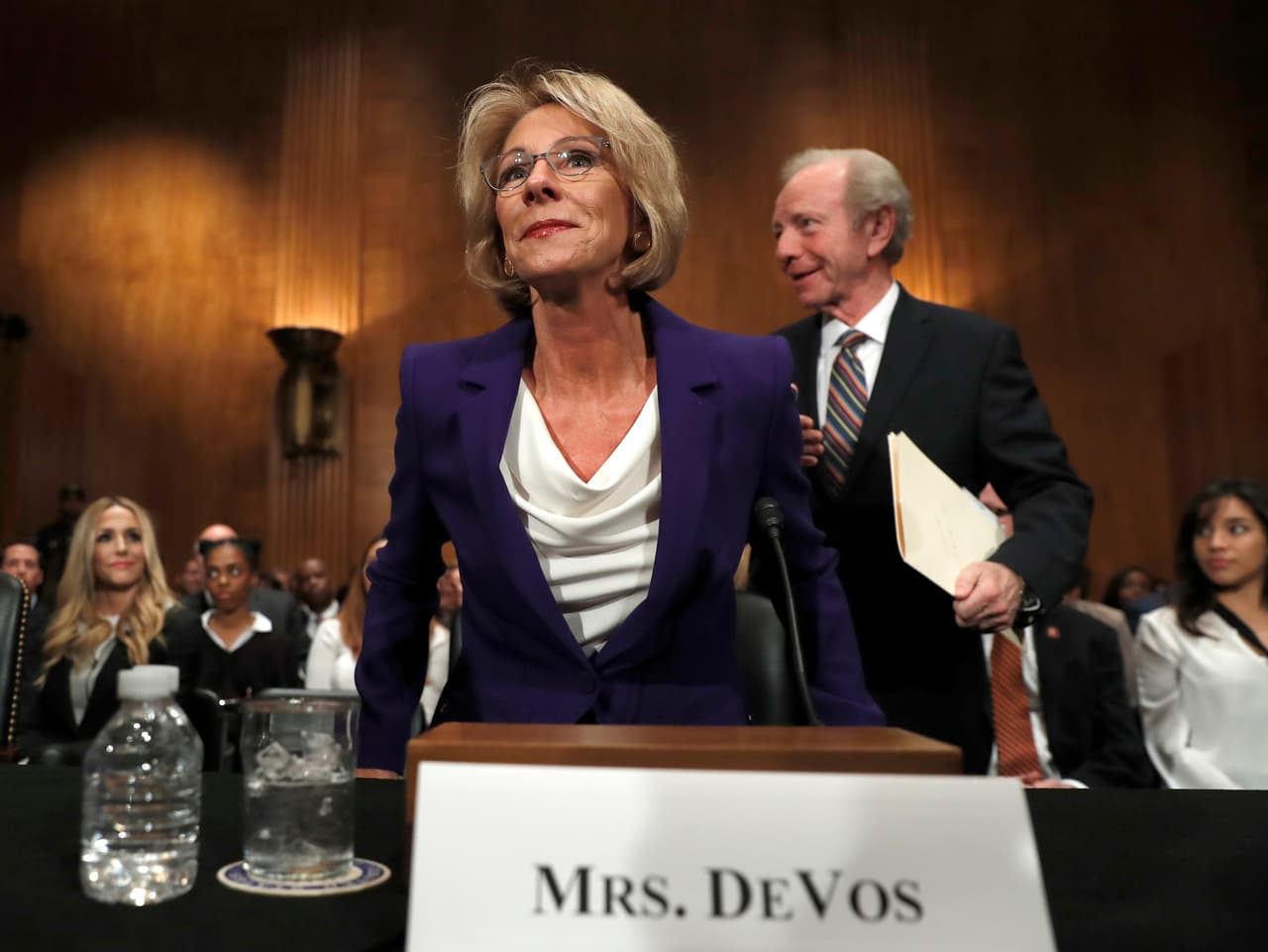 Education Secretary-designate Betsy DeVos arrives with former Sen. Joe Lieberman, right, before testifying on Capitol Hill in Washington, Tuesday, Jan. 17, 2017, at her confirmation hearing before the Senate Health, Education, Labor and Pensions Committee. (AP Photo/Carolyn Kaster)