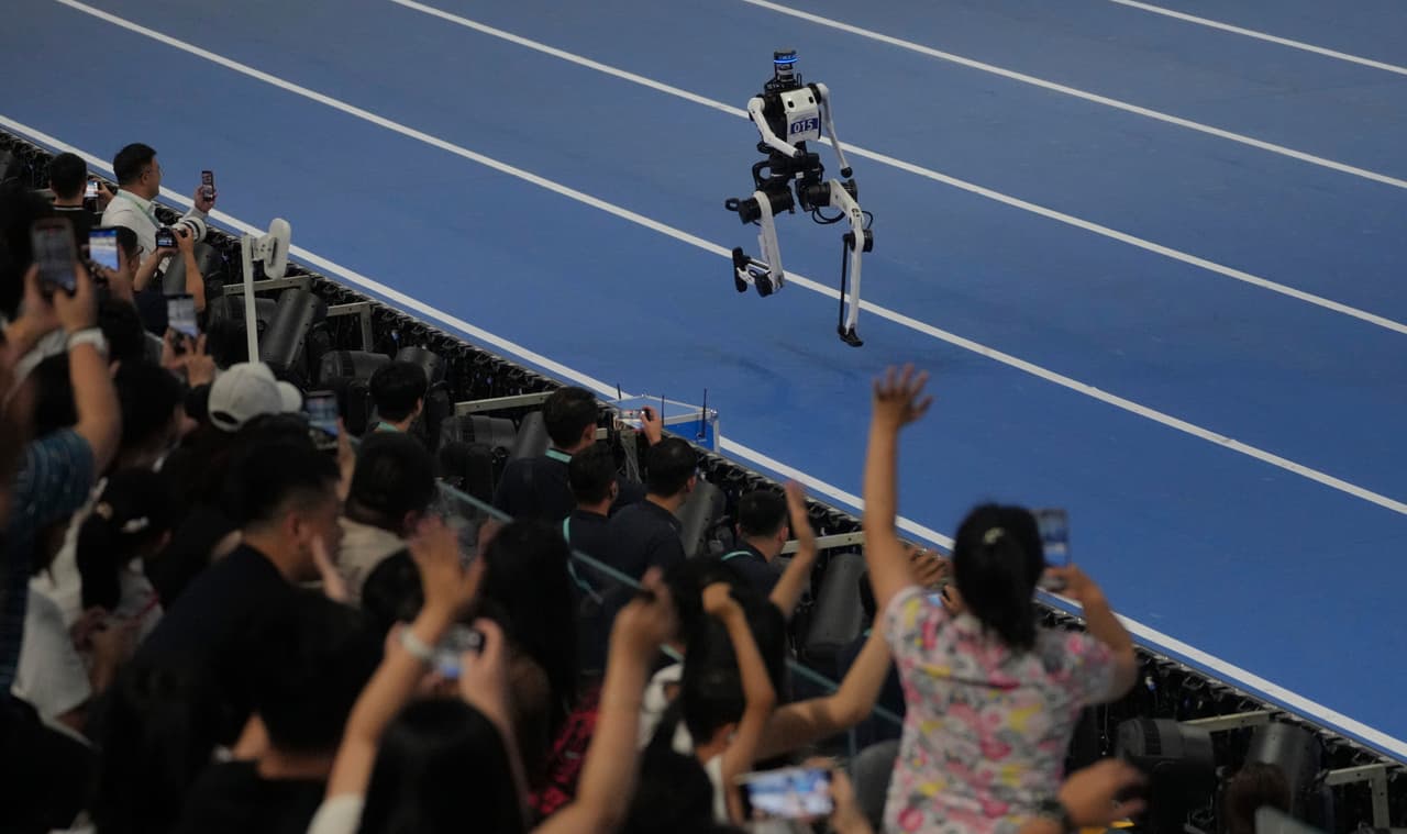Los espectadores vitorean a un robot que compite en la prueba de 1500 metros durante los Juegos Mundiales de Robots en Pekín.