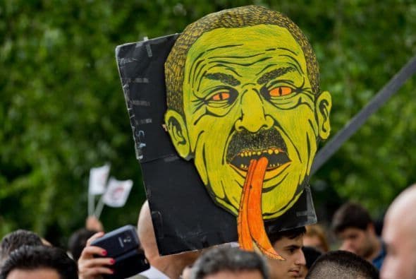 Aquí, un manifestante que sostiene un dibujo que representa a Erdogan.