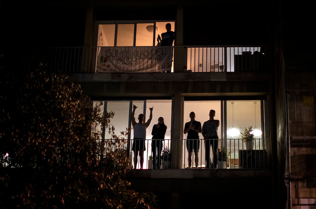 Personas gritan y aplaude desde sus balcones en Barcelona en apoyo del personal médico que trabaja en la pandemia de coronavirus. España es el segundo país más golpeado de Europa luego de Italia.
