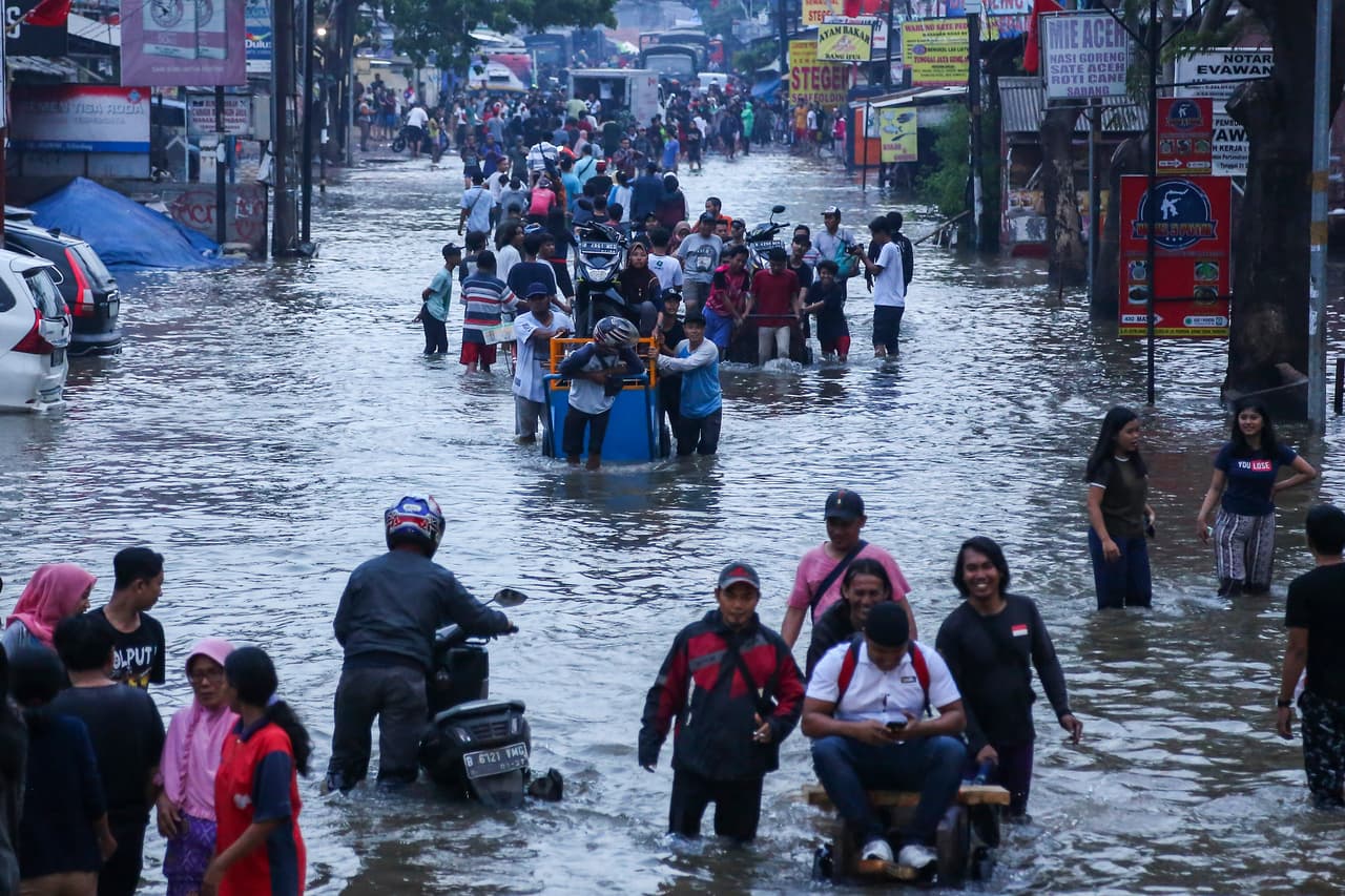 Las lluvias comenzaron a fines de diciembre, poco antes de despedir el 2019. En esta foto, residentes de la ciudad de Tangerang, en la provincia de Banten, se abren paso entre las aguas que cubrieron las calles.
