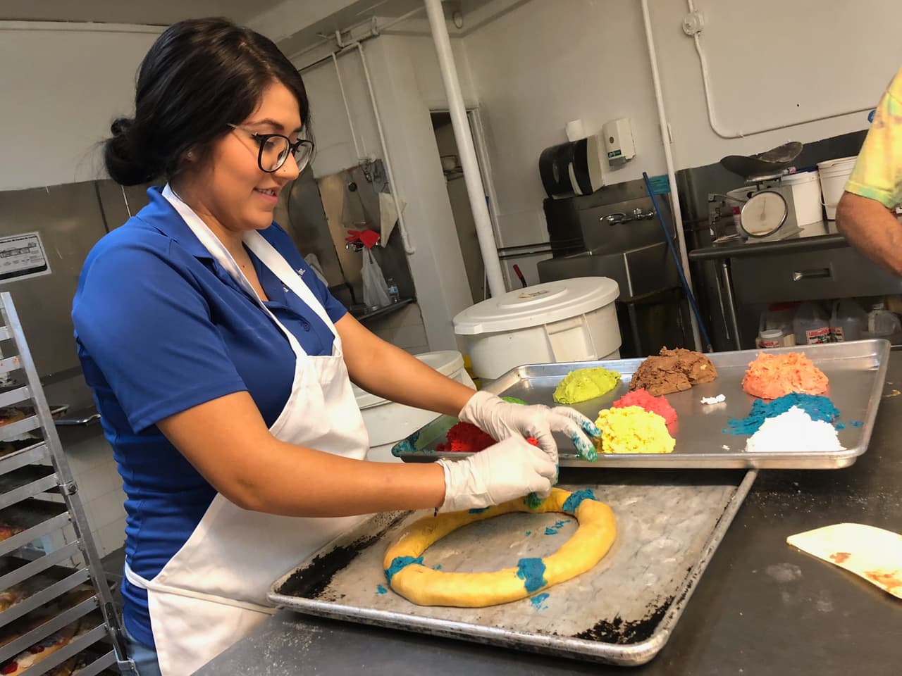 Jessica Franco decora una rosca pequeña con los diferentes dulces de colores.