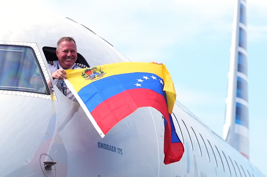 El capitan Ric Wilson ondea la bandera de Venezuela antes de despegar de Miami rumbo a Maiquetía.