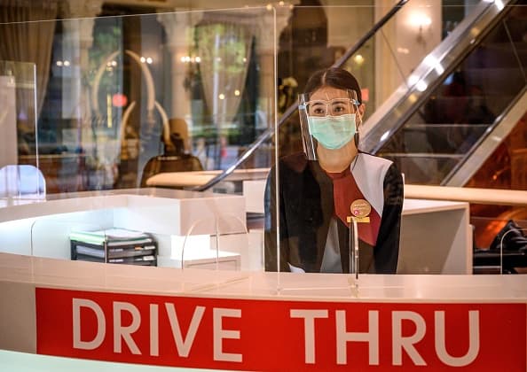 Un asociado de la tienda limpiará los carriles de pago después de cada transacción con un cliente.