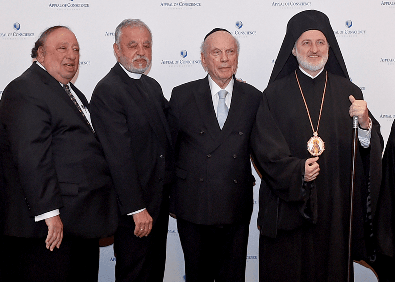 <b>Alejandro Karloutsos</b>
<br>
<br>(En la foto, de izquierda a derecha, el segundo es Alexander Karloutsos). El padre Karloutsos es el exvicario General de la Arquidiócesis Ortodoxa Griega de EEUU. Después de más de 50 años como sacerdote, fue nombrado Protopresbítero del Patriarcado Ecuménico.
<br>