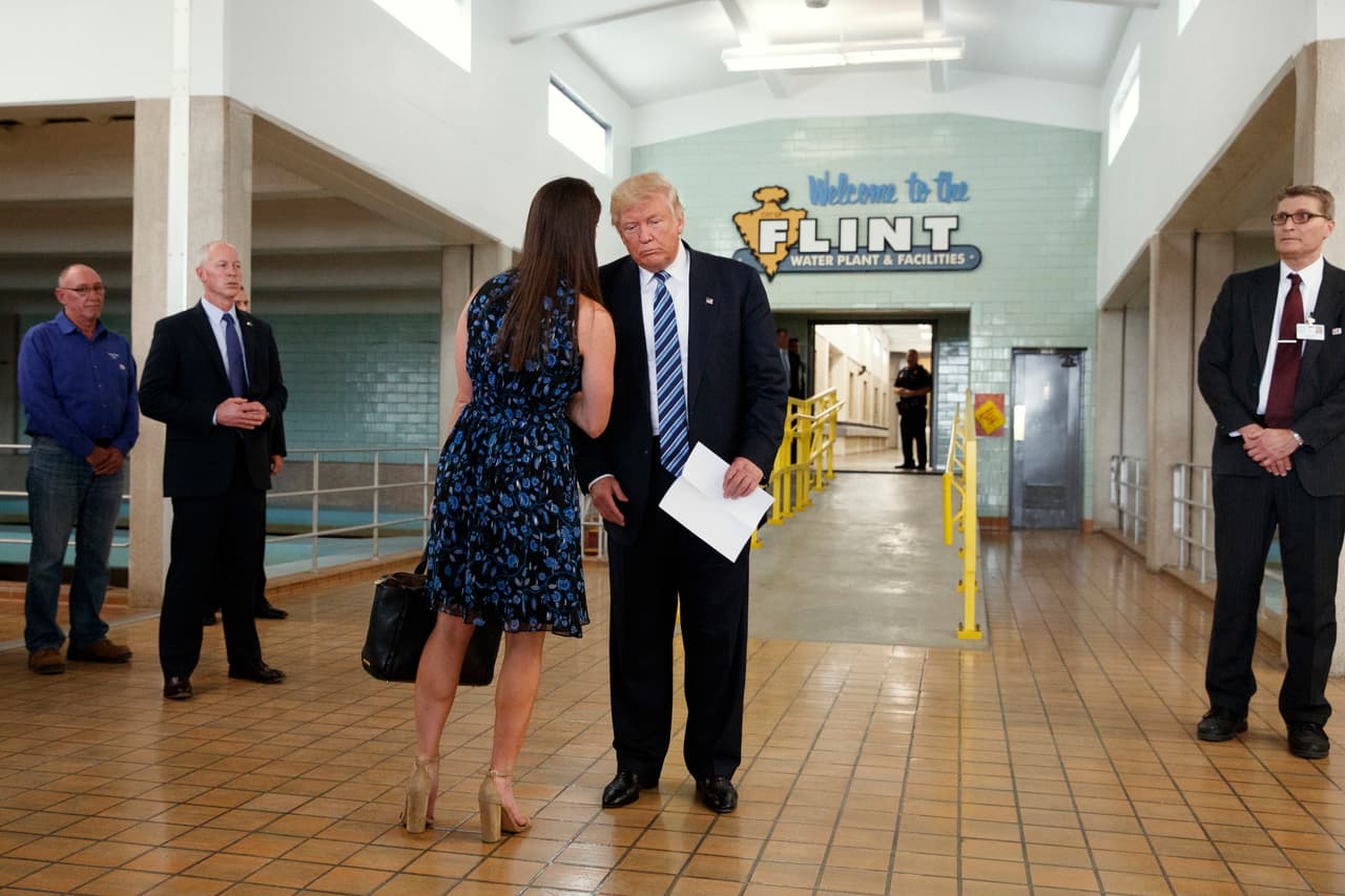 <b>Talking in the ear of the boss. </b>The campaign's press secretary briefs the candidate, during the visit to the water plant in Flint, Michigan. September 14, 2016.