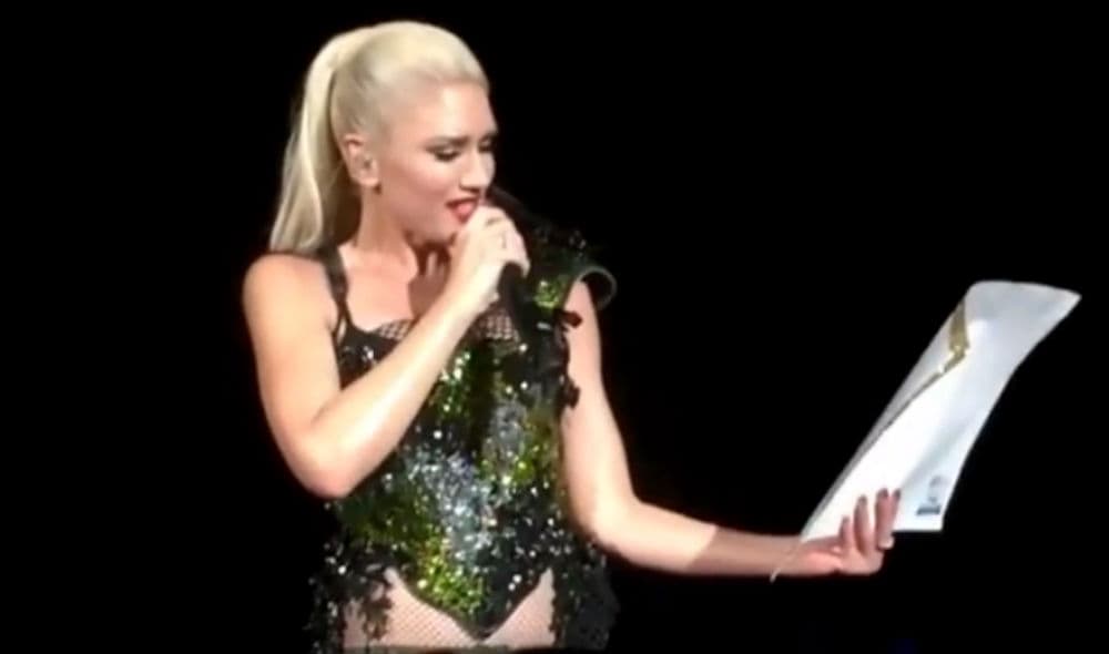 Gwen Stefani leyendo el mensaje en pleno concierto