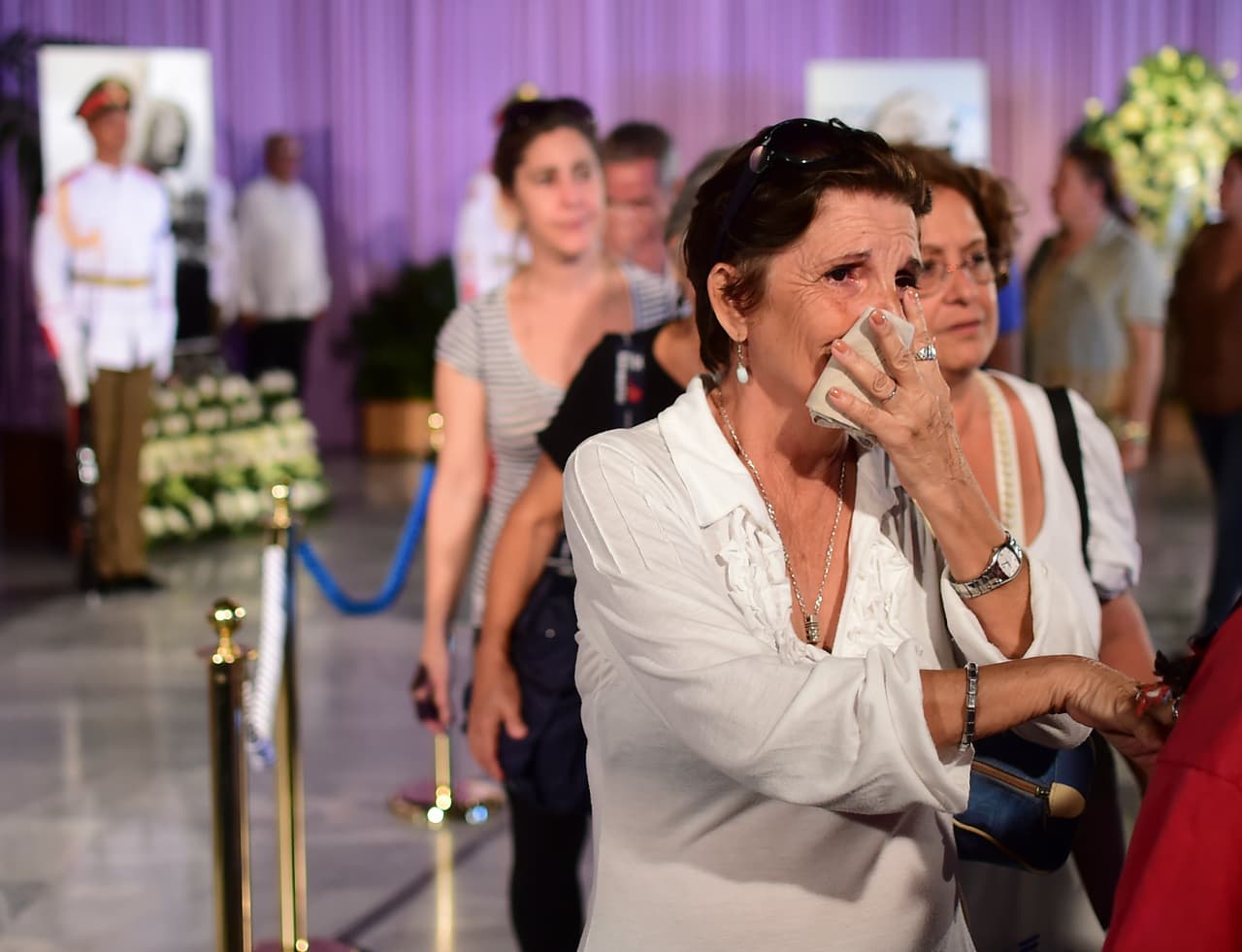 Una mujer llora luego de pasar frente a los restos de Fidel Castro, en el primer día de funerales de estado.