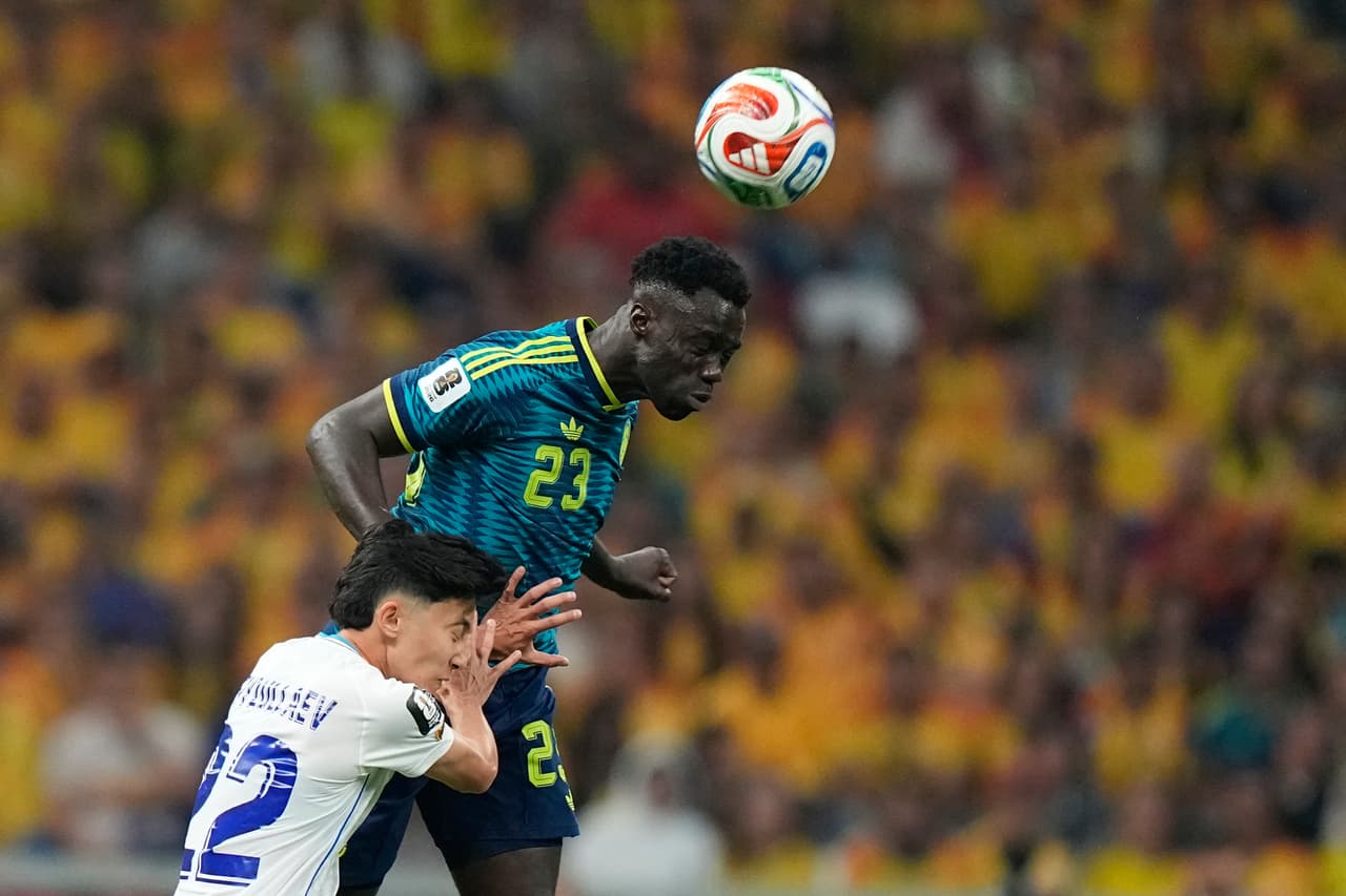 Davinson Sánchez (23), de Colombia, disputa el balón con Abbosbek Fayzullaev (22), de Uzbekistán, durante el partido de fútbol del Grupo K de la Copa Mundial entre Uzbekistán y Colombia en la Ciudad de México.