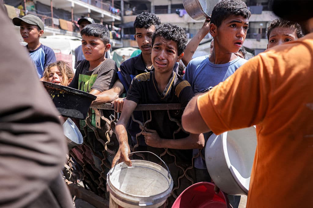 Imagen de niños hambrientos en Gaza, esperando para recibir algo de comer de una cocina de caridad, tomada por el fotoreportero de la AFP, Bashar Taleb.