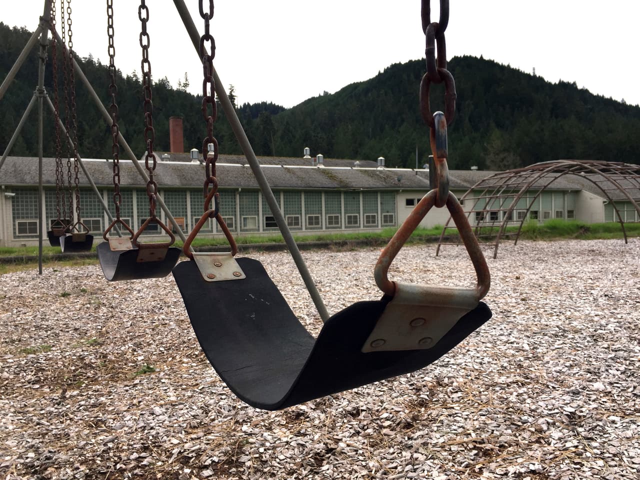 El patio abandonado de la escuela primaria. El pueblo está en el condado de Douglas, a orillas del río Umpqua Sur, de aguas color verde esmeralda. La comunidad tiene una elevación de 1,020 pies y está rodeada por el Bosque Nacional Umpqua. La 
<b>industria maderera colapsó en la década de 1990 por restricciones de tala en bosques nacionales</b>, lo que llevó a gran parte de la población a alejarse de allí.
