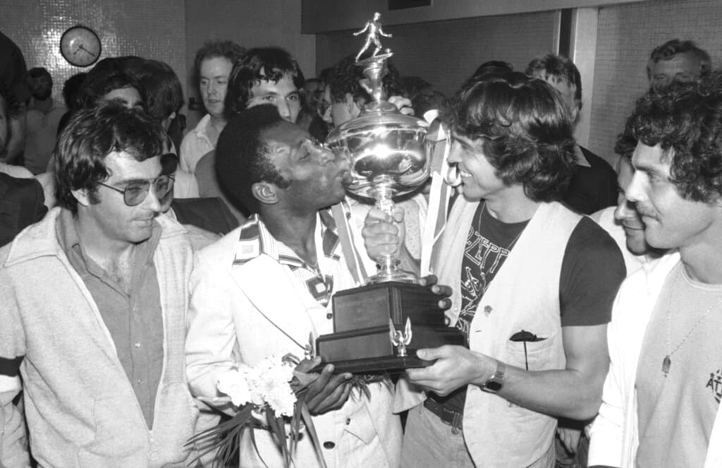 En esta foto de archivo del 29 de agosto de 1977, el jugador de fútbol del New York Cosmos, Pele, centro izquierda, besa el trofeo de su equipo en el Aeropuerto Kennedy de Nueva York tras ganar el campeonato de la Liga Norteamericana de Fútbol contra los Sounders de Seattle.