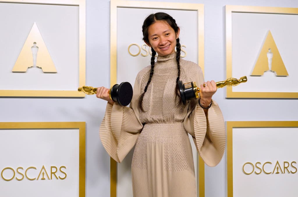 La directora y productora Chloe Zhao, levanta las estatuillas por Mejor dirección y Mejor fotografía, por su película "Nomadland".
