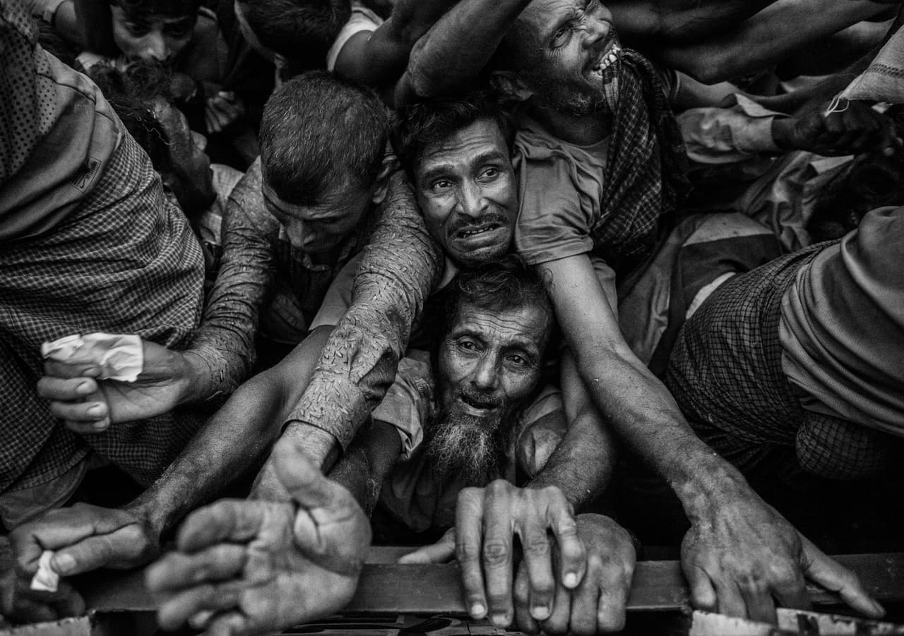 Refugiados rohingya en Cox’s Bazar, Bangladesh, luchan por obtener comida distribuida por una ONG. La negación absoluta de Myanmar sobre la comunidad se traduce en una persecusión violenta por parte de las fuerzas del país. Miles de rohingyas huyen como pueden hacia Bangladesh cada año, éxodo que con el recrudecimiento de la violencia en los últimos meses, se agravó.