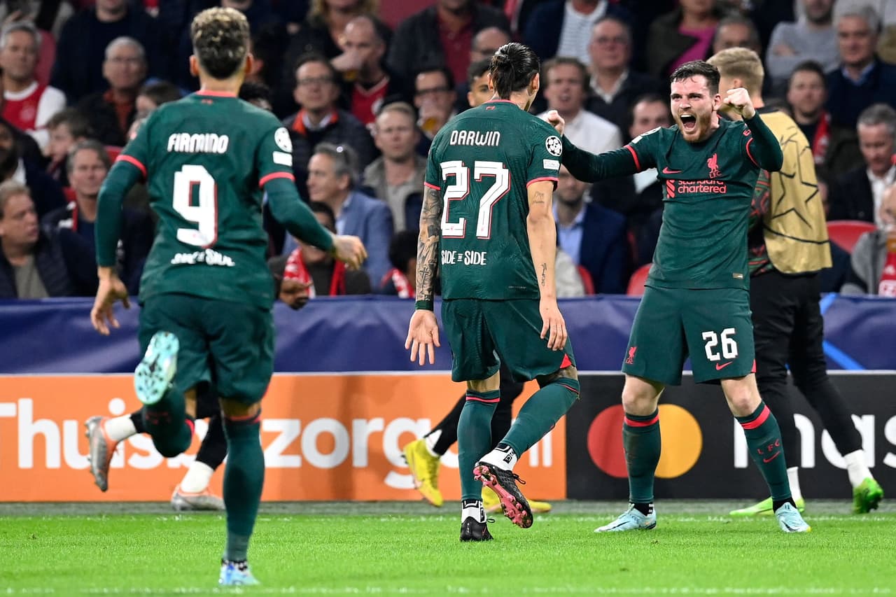 Liverpool's Uruguayan striker Darwin Nunez (C) celebrates scoring his team's second goal with Liverpool's Scottish defender Andrew Robertson (R) during the UEFA Champions League group A football match between Ajax Amsterdam and Liverpool at the Johan Cruijff ArenA in Amsterdam, on October 26, 2022. (Photo by JOHN THYS / AFP) (Photo by JOHN THYS/AFP via Getty Images)