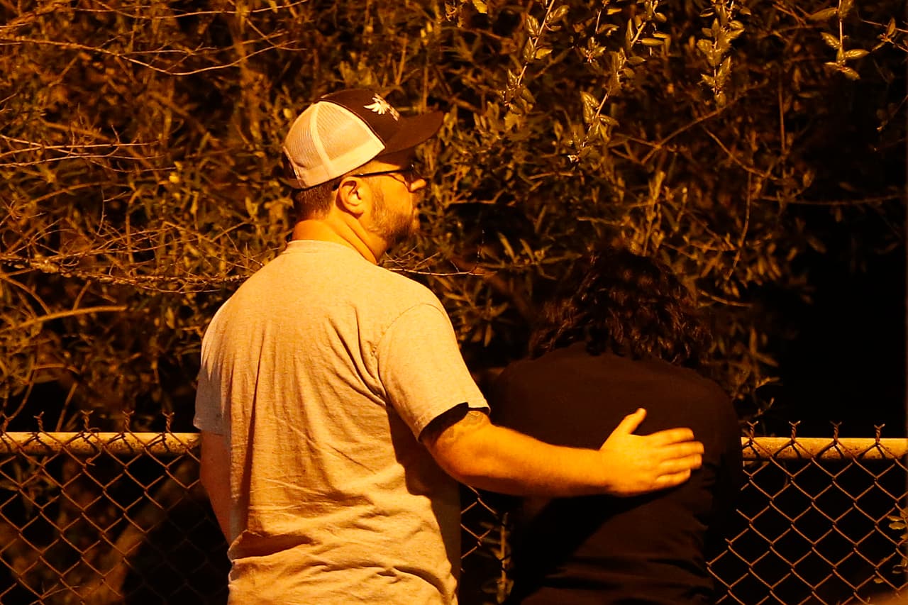 Un hombre y una mujer esperaban afuera del centro de veteranos para saber noticias de los suyos.