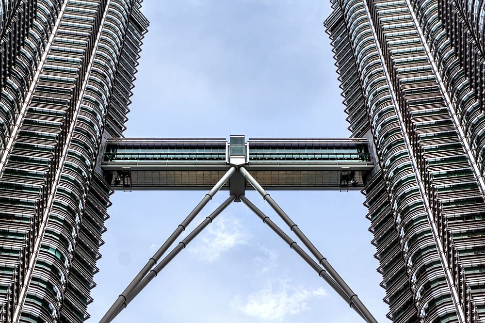Elevándose a una altura de 451.9 metros, la estructura gemela de 88 pisos es la joya de la corona de Kuala Lumpur. Majestuosas de día y deslumbrantes de la noche, las Torres Gemelas de PETRONAS están inspiradas en la visión de Tun Mahathir Mohamad de que Malasia fuera un jugador global. Pelli, el ícono internacional, capturó poderosamente las ambiciones y aspiraciones de la nación.