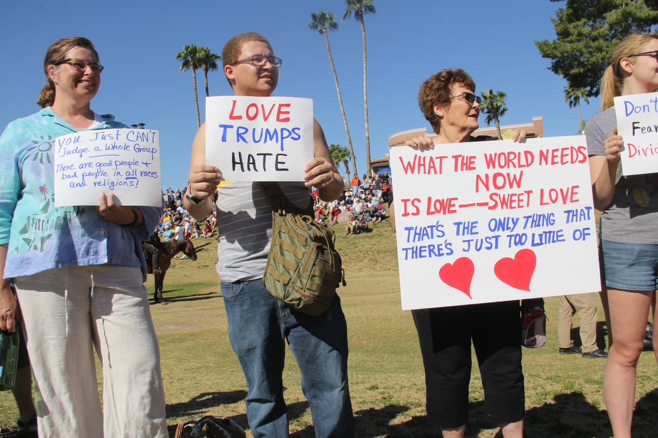 Este grupo de personas mostraban carteles contra el odio a los seguidores de Trump que entraban al escenario cercado.