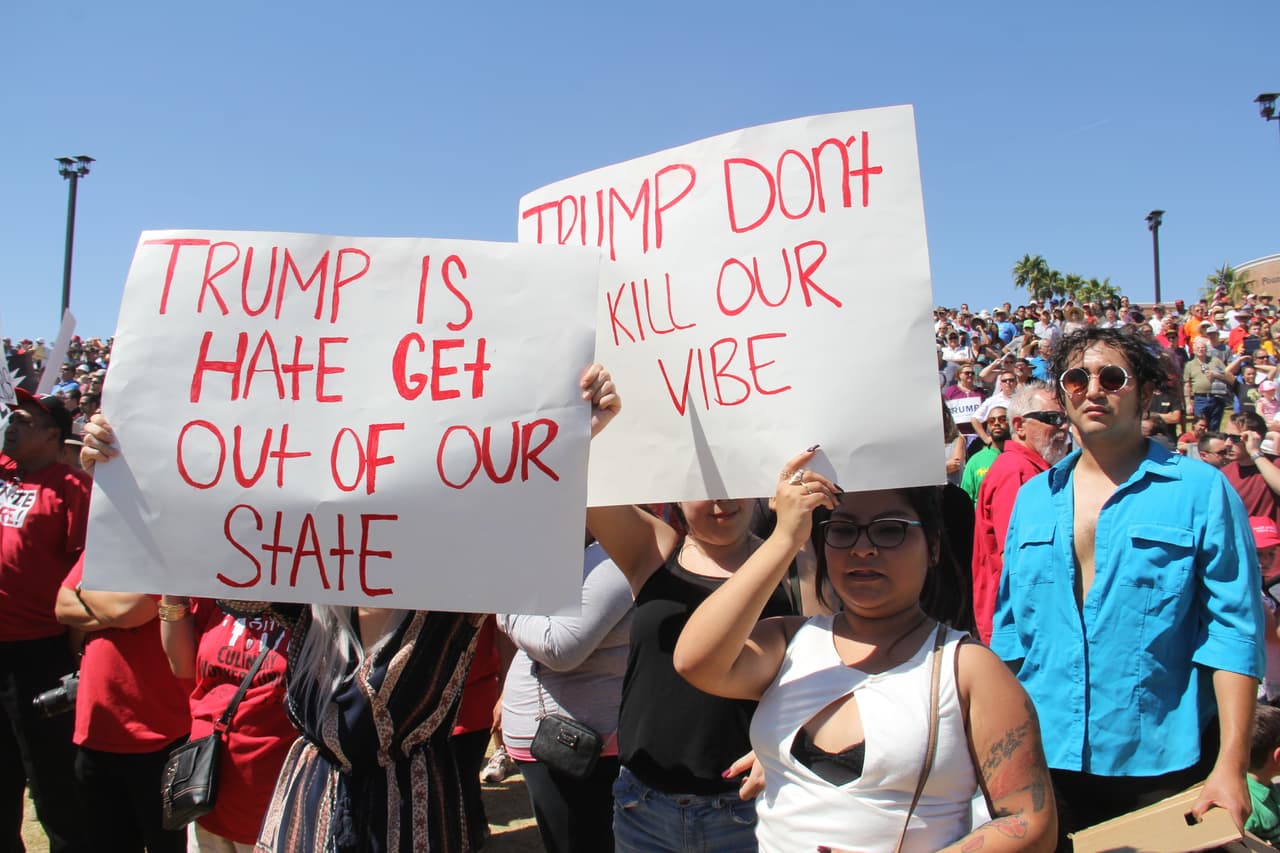 Mientras Trump hablaba en el escenario, decenas de detractores caminaban entre los simpatizantes de Trump con pancartas.