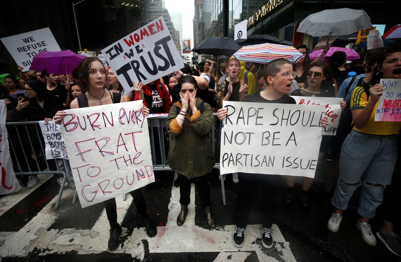 “Arrasemos cada fraternidad (grupos de estudiantes universitarios como el que hizo referencia Kavanaugh en las audiencias)”, se lee en el cartel de la Izquierda. “Confiamos en las mujeres”, al centro y “La violación no debería ser un asunto partidista”, a la derecha. Vistos frente a la Torre Trump de Nueva York.