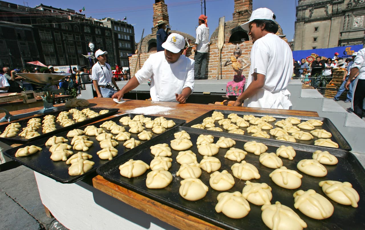 Divide la masa en 4 partes y a cada una quítale una pequeña porción que usarás para los adornos del pan.