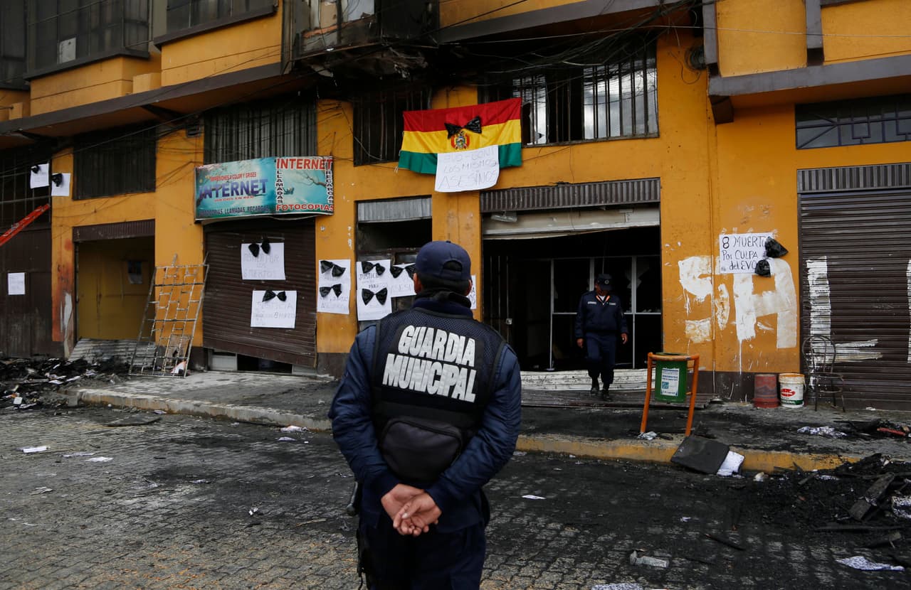 Un trabajador municipal observa el edificio del municipio que fue incendiado por manifestantes en El Alto, Bolivia, el miércoles 17 de febrero de 2016. Seis funcionarios de la alcaldía murieron y otros 28 quedaron heridos después que manifestantes asaltaron y quemaron sus oficinas tras una marcha por residentes que exigen mejores escuelas y más maestros. (Foto AP / Juan Karita)