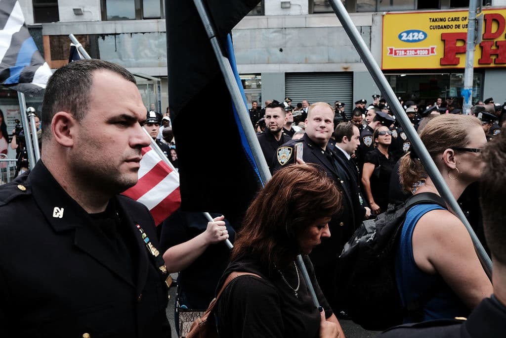 Un grupo de policías marcha antes del funeral junto a residentes de El Bronx. "Era una de las nuestras, era hispana", dijo una mujer entrevistada por Univision 41. (Spencer Platt/Getty Images)