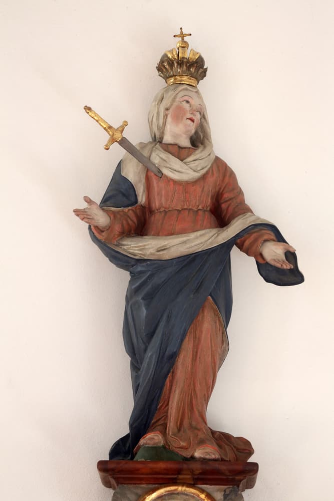 Sus vestiduras también varían depende del país o la cultura, pero suelen ser tonos oscuros, como rojo, azul, negro y morado. Hay otras que además de la daga clavada le incluyen una corona de espinas o hasta lágrimas pintadas en su rostro.