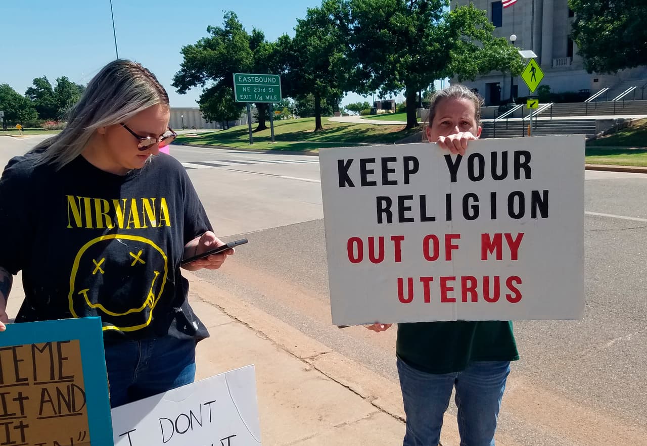 En Oklahoma City: 
<b>"Mantén tu religión fuera de mi útero".</b>